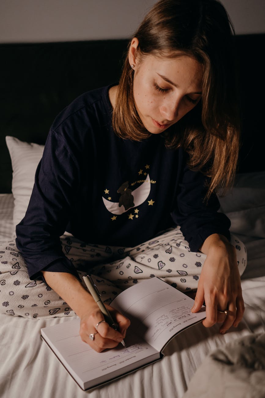 photo of a woman writing on a planner
